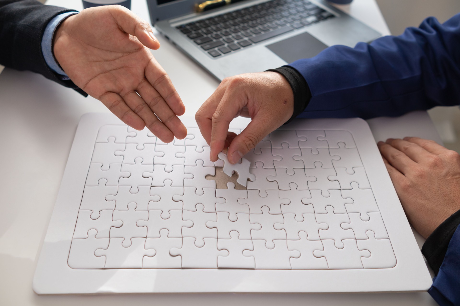 In hands of businessmen and investors they hold jigsaw pieces to put together in right way to make the jigsaw pieces symbolize their participation in business ventures. Venture capital symbol concept